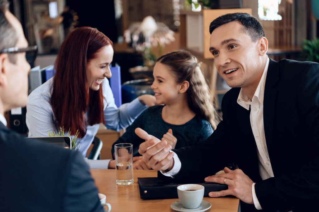 XConfident father, red head mother and little smiling daughter are sitting in lawyer's office.
